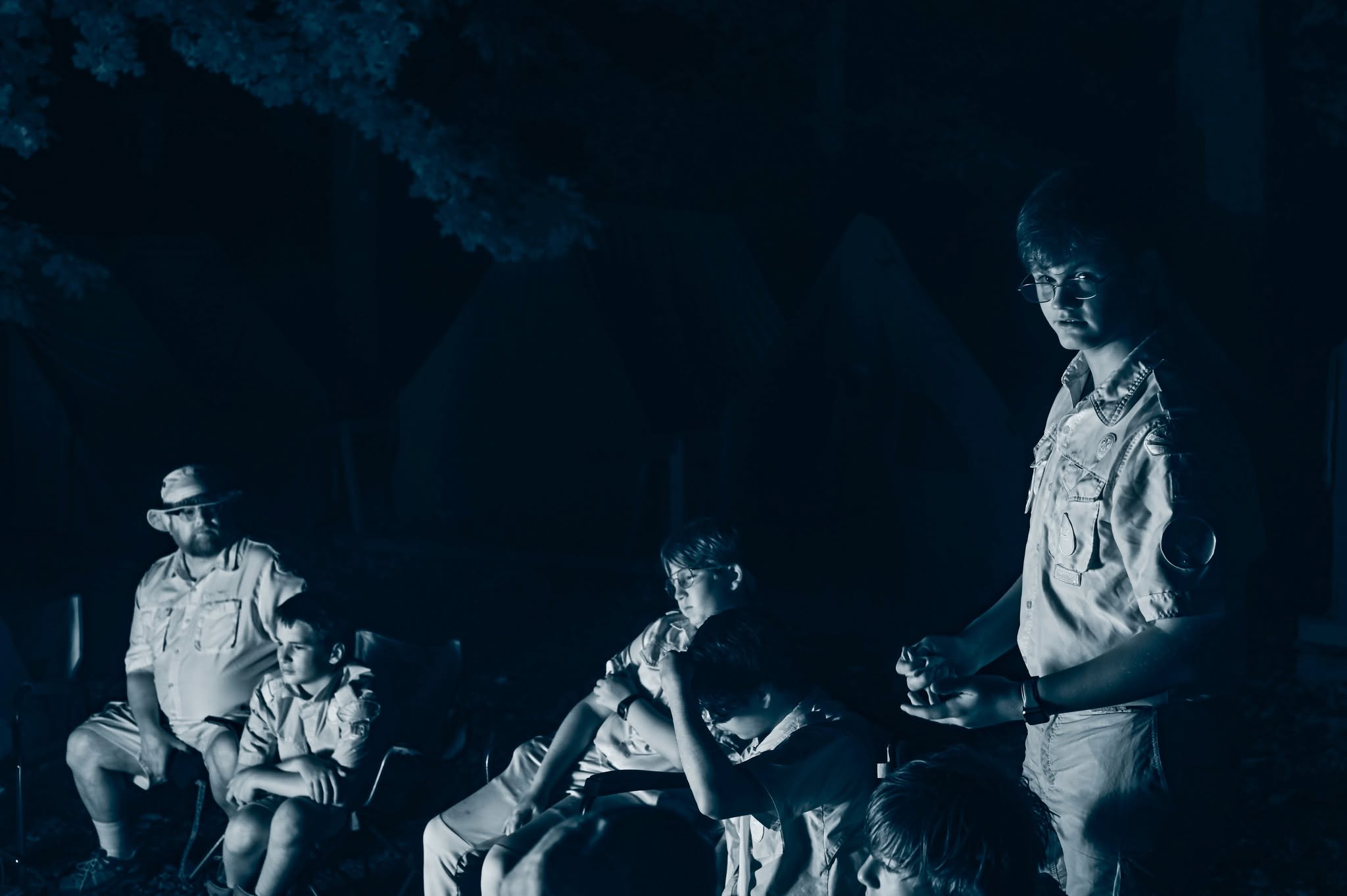 A scout leading discussion by the campfire